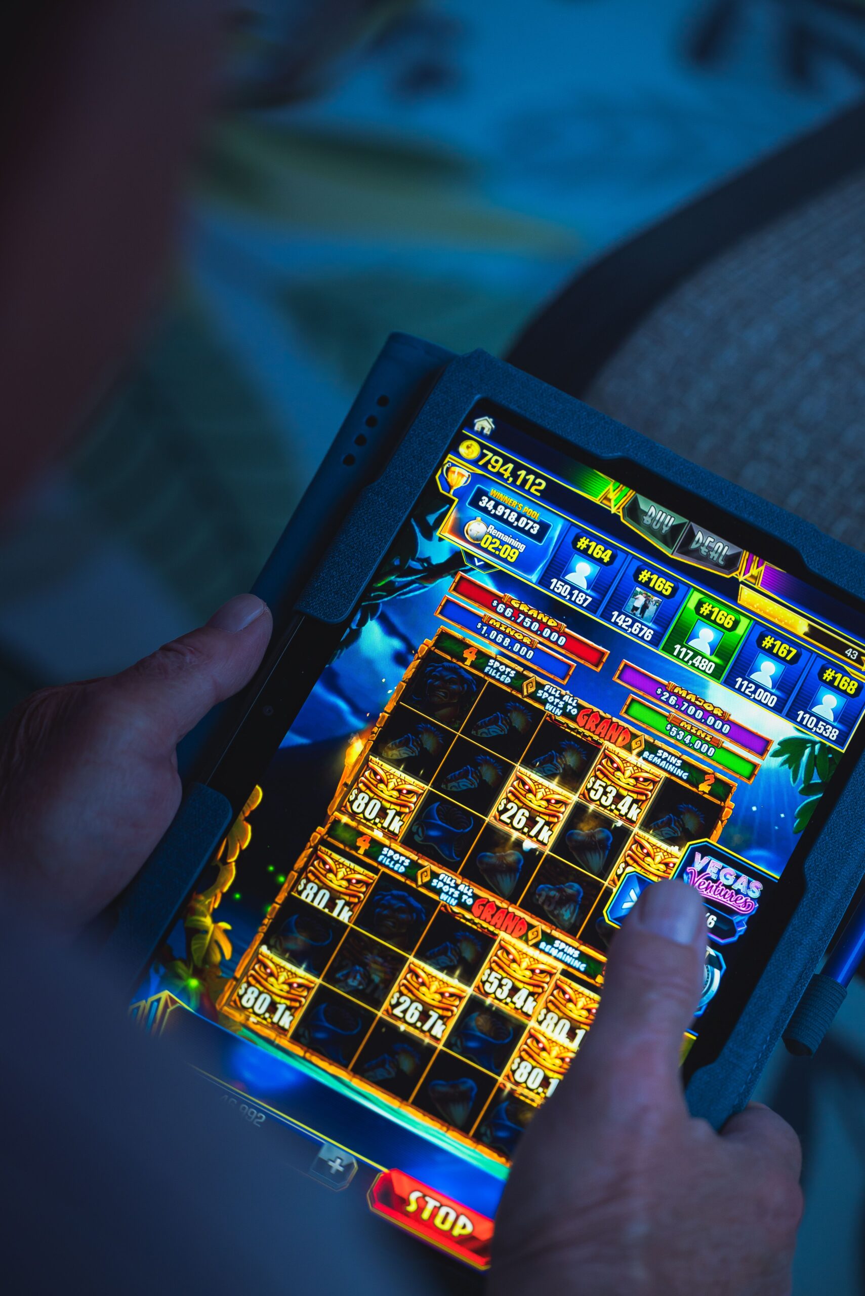 Person playing a mobile game on a tablet, focused on fun and entertainment.